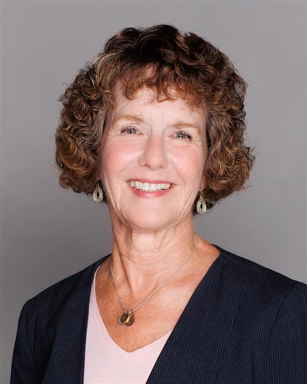 Linda Druan, Board Member, headshot photo in front of grey background.